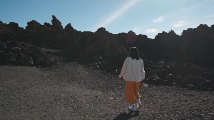 旅游妇女在特内里费岛的泰德火山国家公园中穿过凝固的熔岩山