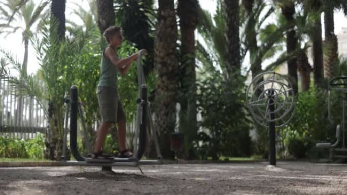 Teenage boy exercising on cross-trainer in outdoor