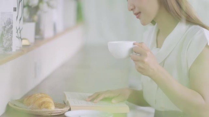 年轻女子坐在吧台旁喝咖啡，安心看书的侧视图。