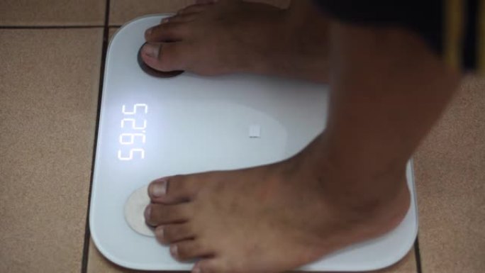 男孩在数字秤上检查自己的体重