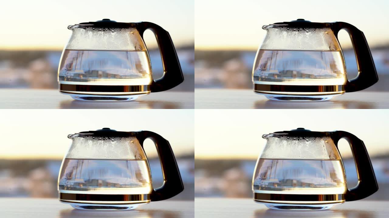 早晨的阳光下，用新鲜酿造的红叶茶制成的玻璃水壶。