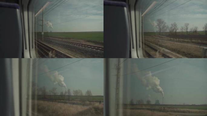 从火车窗口看，德国巴伐利亚州有两个蒸汽冷却塔的核电站。欧洲的生态与污染话题。天气晴朗时工厂烟囱冒烟。
