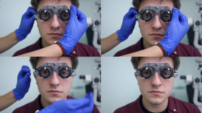 医生用手调节室内医院病人试验架中的镜头。近距离无法辨认的高加索眼科医生在眼科诊所检查年轻人的视力。眼