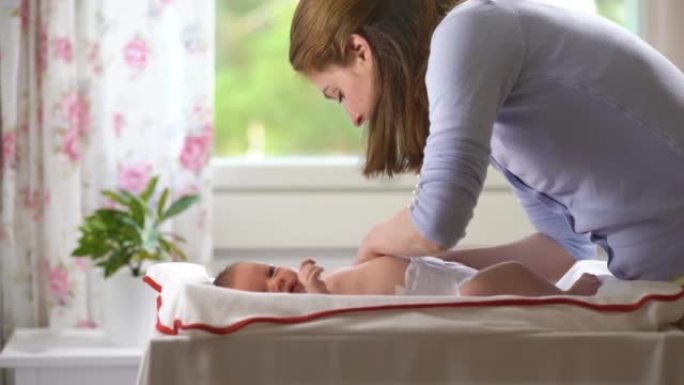 年轻的母亲给婴儿换尿布