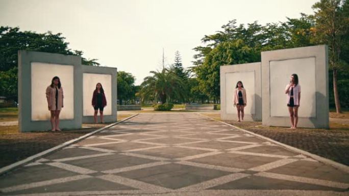 在公园里，一群亚洲女性分别站在一堵墙前，表情非常可怕