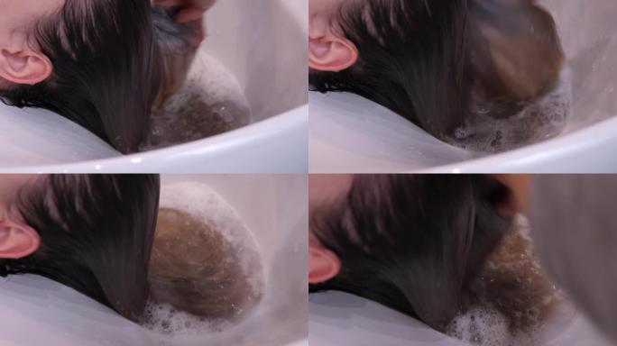 沙龙发型师的发型过程在处理程序后为女性客户洗头