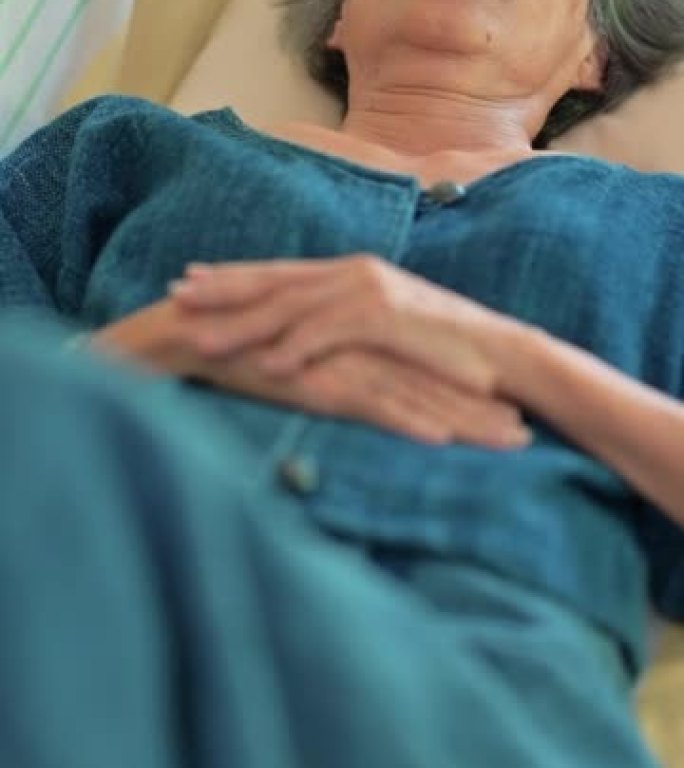 Asian senior woman feeling sick and taking a nap