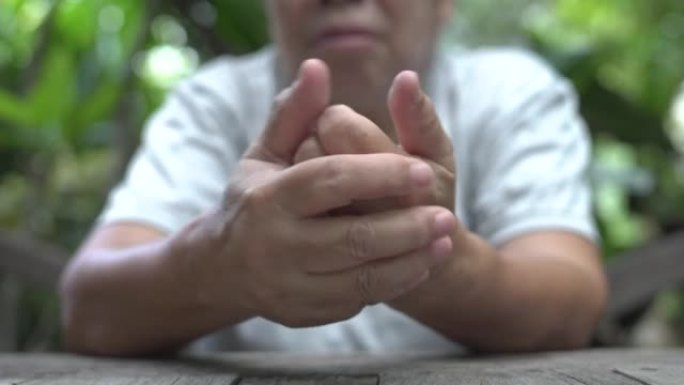 亚洲老年妇女手部疼痛，锁指疾病，肌肉无力。