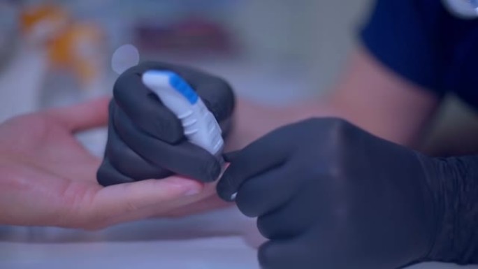 医生使用自动儿科柳叶刀从手指上取血