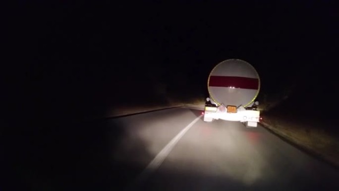 卡车在夜间在高速公路上运送一箱可燃燃料