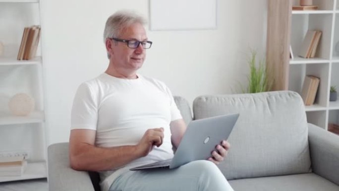 在线聊天家庭休闲男子在沙发上使用笔记本电脑
