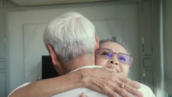4k视频片段，一对老年夫妇在家里享受时光，拥抱，微笑，福利退休夫妇肖像概念