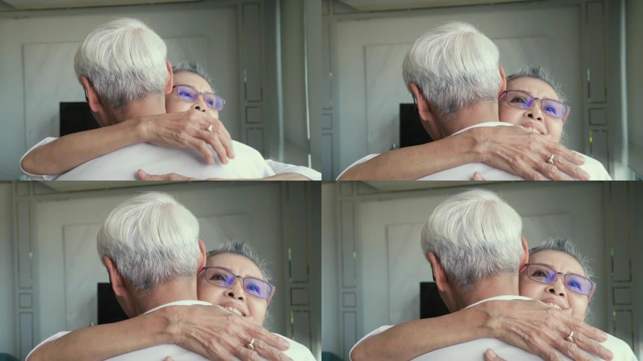 4k视频片段，一对老年夫妇在家里享受时光，拥抱，微笑，福利退休夫妇肖像概念