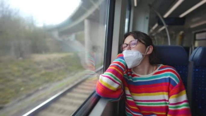 新型冠状病毒肺炎大流行期间戴口罩的女人在火车上旅行