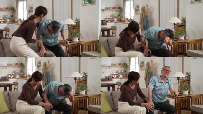 亚洲老爸的慢动作，膝盖疼痛，难以站立。他的成年女儿迅速过来帮助他坐下并给他按摩