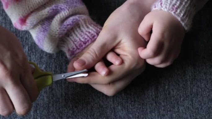 妈妈剪了她小女儿的指甲。