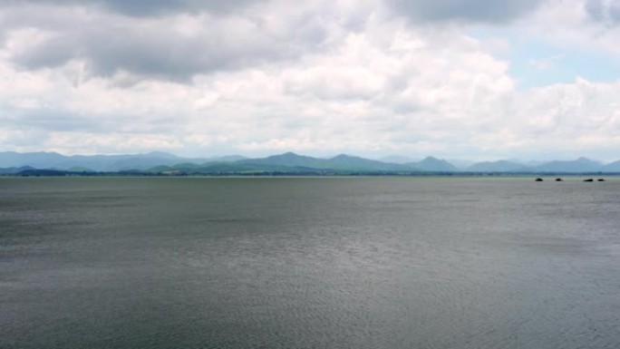 风吹水在群山环绕的水坝中，阴云密布的天空即将落在泰国北碧府的Kra Siew大坝上。