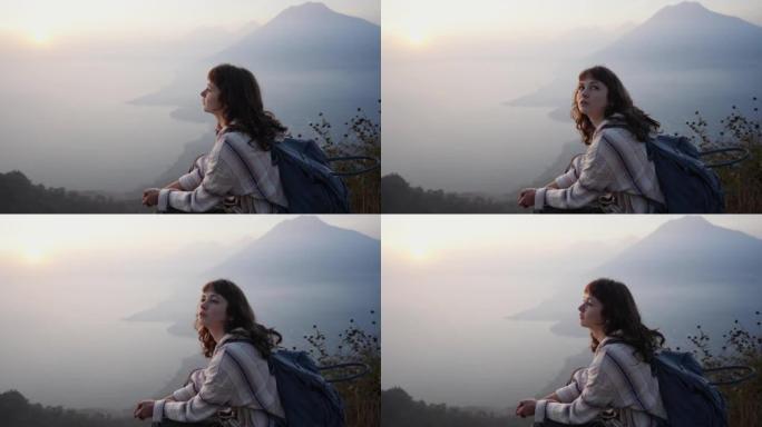 日落时分，坐在危地马拉阿蒂特兰湖背景上的女人