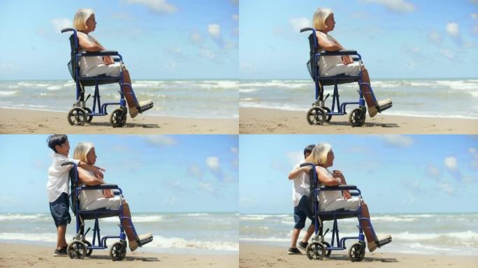 孙子夏天和坐轮椅的奶奶在海滩上玩得很开心。多代关系的概念