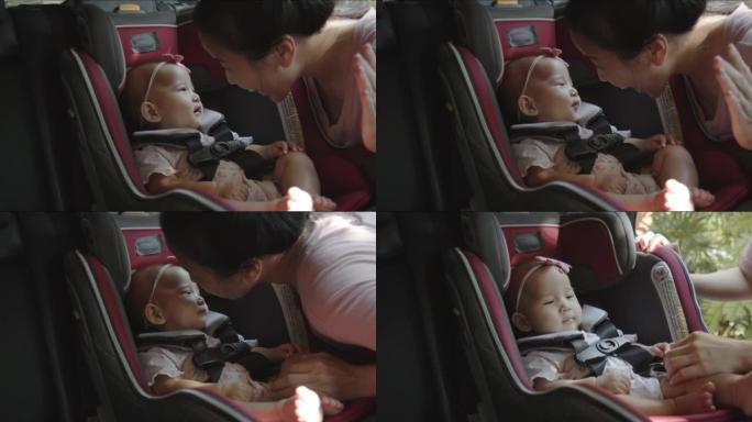 亚洲妈妈和婴儿坐在汽车座椅上玩耍，为家庭公路旅行做准备。快乐的幼儿练习安全的汽车旅行。乘客安全产品概