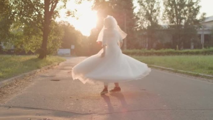 日出时，穿着白色婚纱和士力架的新娘在路上旋转。