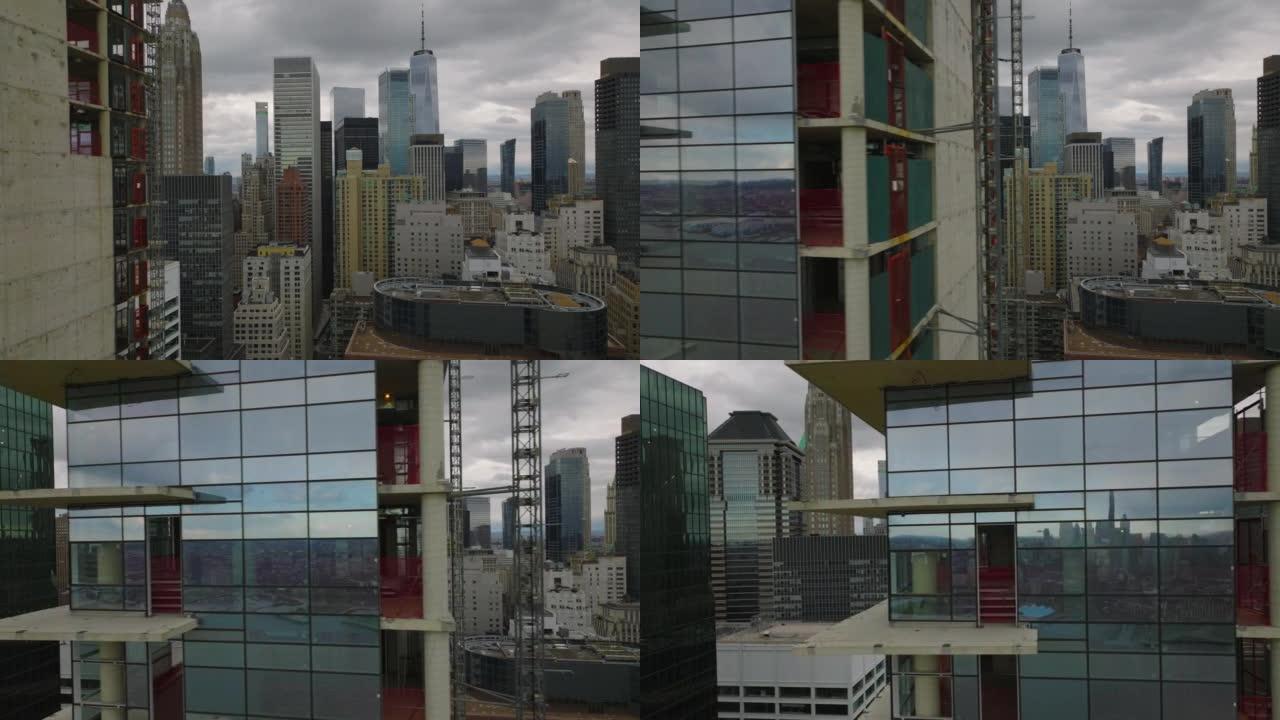 玻璃立面新型现代高层建筑施工现场滑动展示。市中心的摩天大楼在背景阴云密布的天空下。美国纽约市曼哈顿