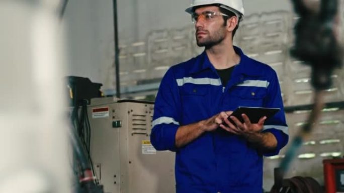 年轻的男性工程师在工业机械装配中组装后检查机器的准备情况。