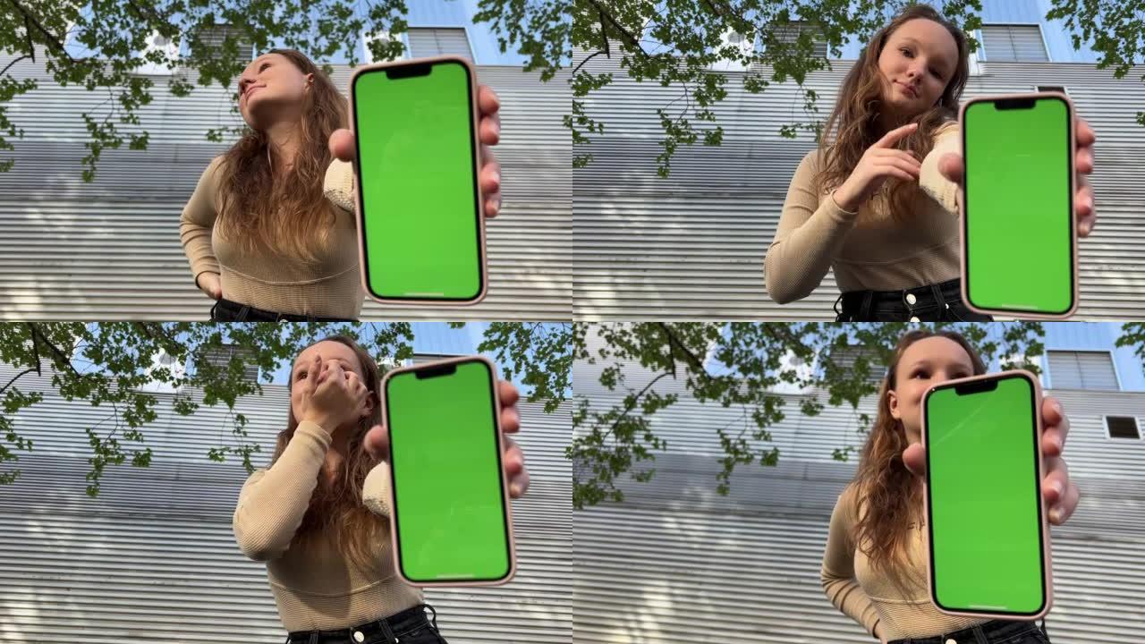 十几岁的女孩与松散的头发棕色头发跳舞与手机欢欣鼓舞在屏幕的跛行绿色屏幕米色背景。