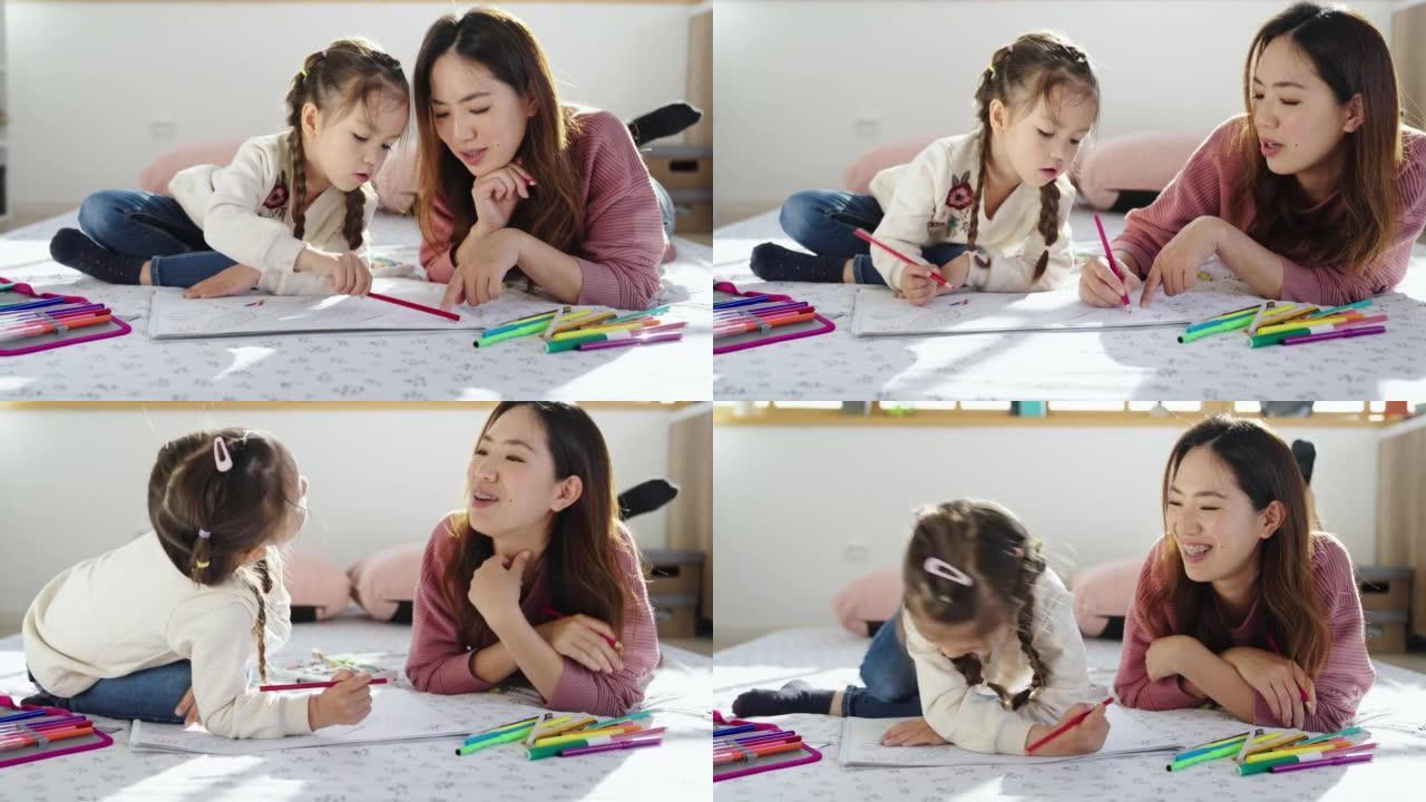 母亲和女儿在卧室里用彩色铅笔画画
