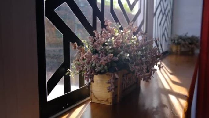 窗台装饰有花、阳光和阴影的木盆