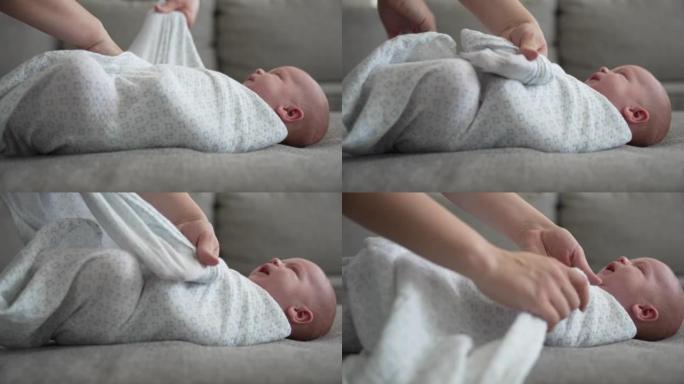 新生儿被母亲包裹在家里的毯子中的特写镜头
