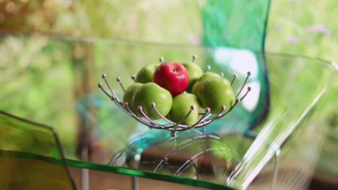 透明玻璃桌上水果篮中的红色和绿色苹果