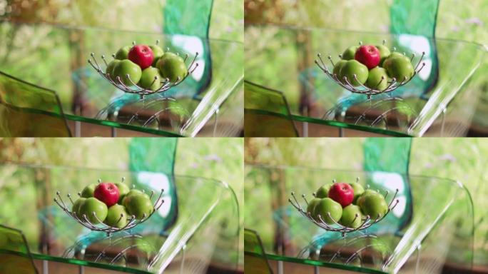透明玻璃桌上水果篮中的红色和绿色苹果