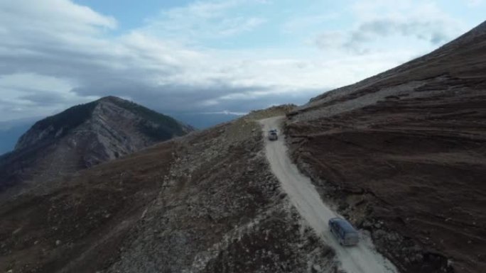 两辆远征越野车正沿着山路的斜坡行驶