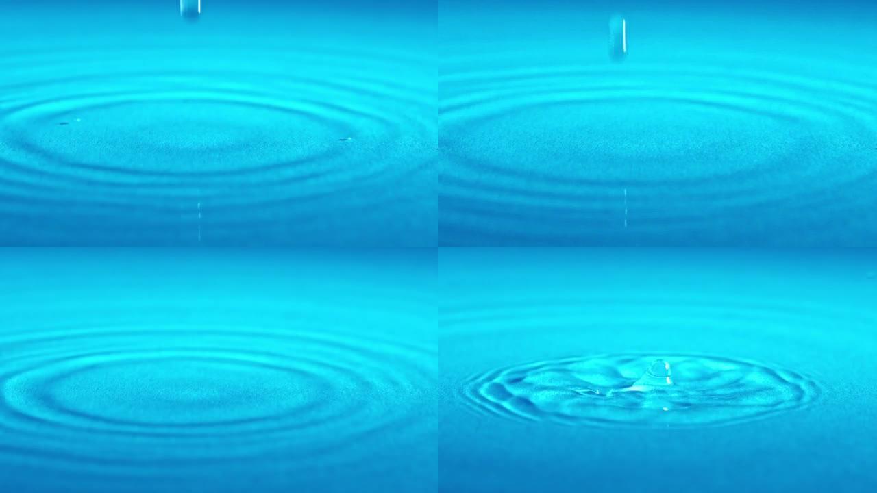 慢动作水滴落在蓝色背景的表面上