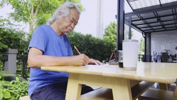 长头发的亚洲男人在家工作。