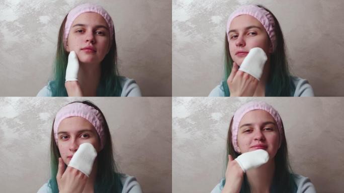 一个十几岁的女孩用乳液，清洁皮肤，美容来清洁她的脸。每日早上面部清洁治疗。青少年痤疮护肤。自然的女性