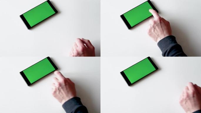 一名男子使用带有绿色显示屏的智能手机。在彩色钥匙智能手机屏幕或绿屏智能手机上滑动手指以复制空间