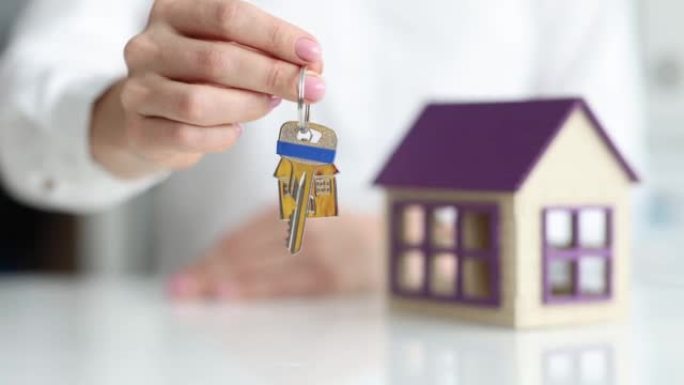 房地产经纪人将钥匙拉到房屋特写