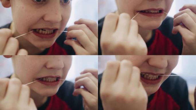 这个男孩用手中的牙线刷牙。特写拍摄