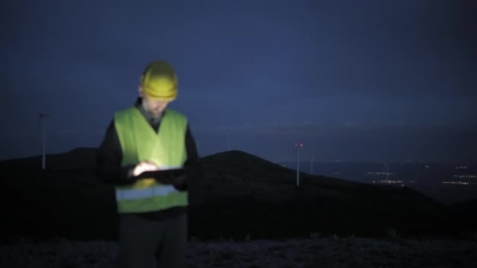 夜间在风电场工作的风能工程师。碳中和和可持续能源。