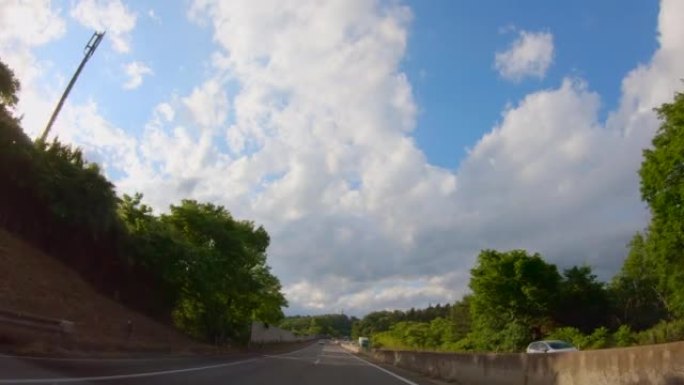在高速公路上行驶的汽车的景色，美丽的蓝天和云