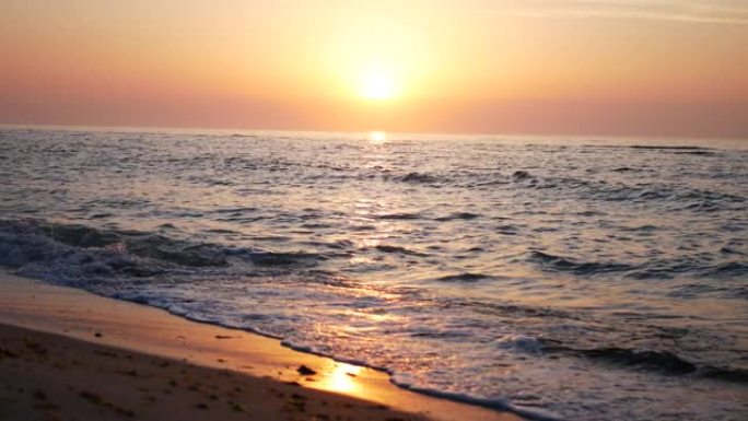 拍摄一个美丽的日落在海上，与柔和的粉红色的水夕阳。