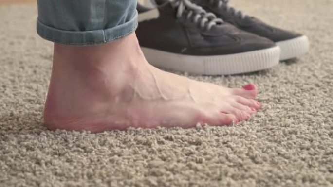 女人的脚和运动鞋在地毯上的特写慢镜头