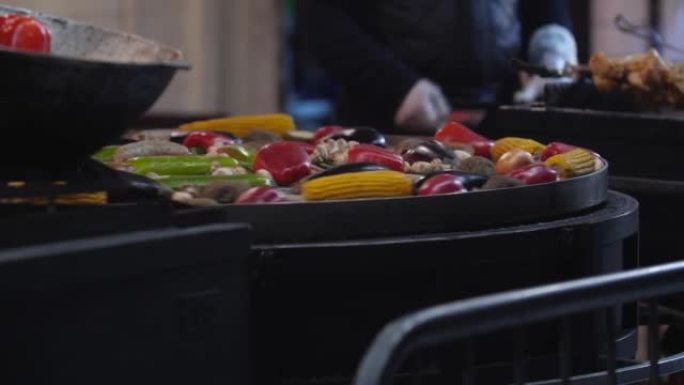 烹饪街头食物。旋转烤架上的蔬菜。冬季交易会，户外贸易。
