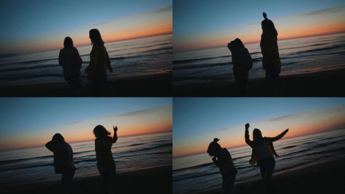 晚上，两个女孩在海边日落时跳舞。