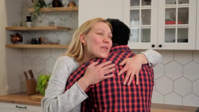 快乐的多民族家庭爱情情侣在家庭厨房拥抱，女人和男人