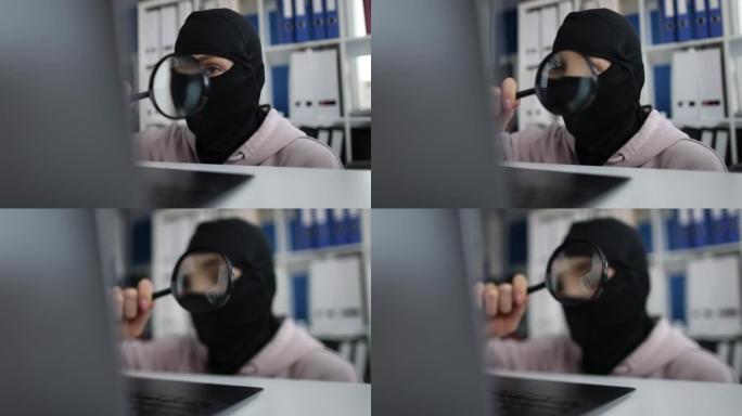 网路窃盗蒙面人用放大镜看电脑萤幕