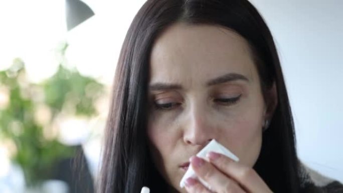 严重流鼻涕的女人手拿药喷入鼻子