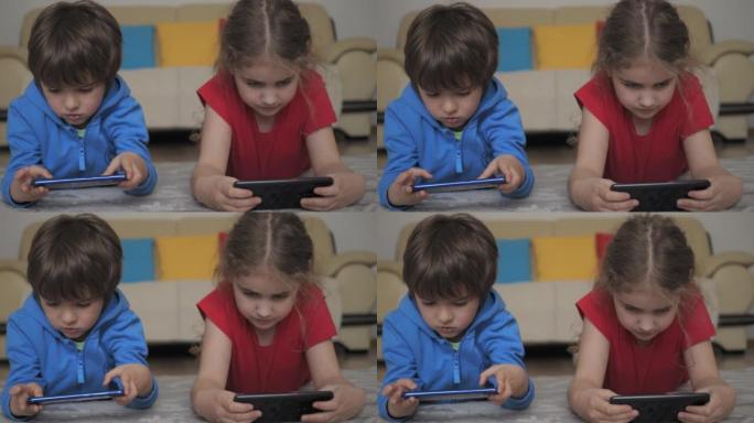 孩子们躺在家里的电话里玩游戏。孩子们在手机上玩视频游戏。男孩和女孩玩电子游戏智能手机。朋友使用手机进